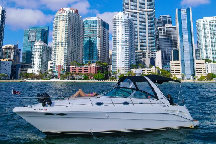 a small boat in a body of water with a city in the background