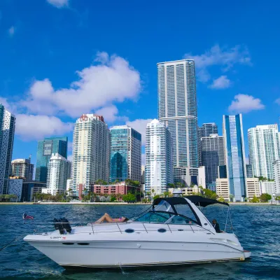 a small boat in a body of water with a city in the background
